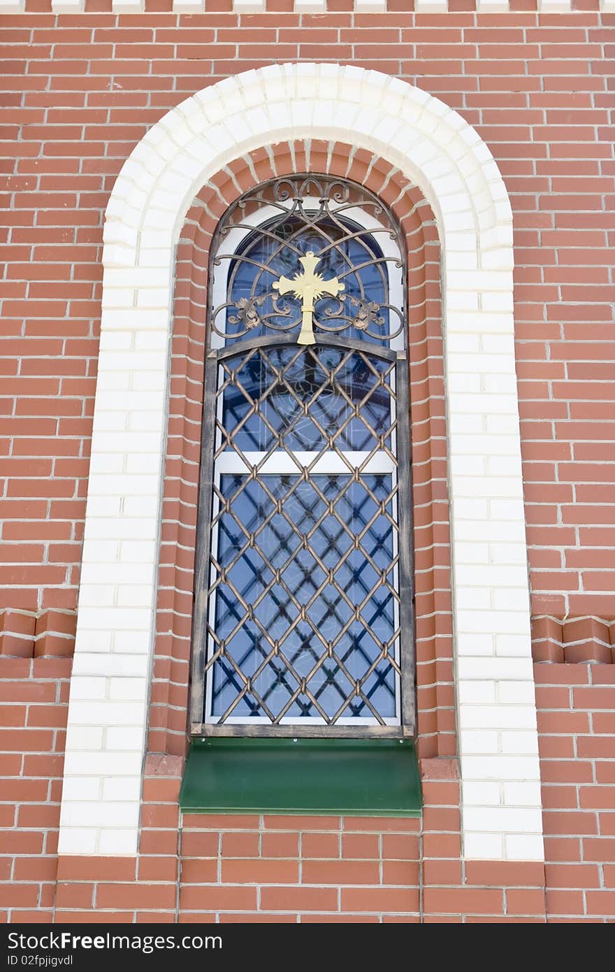 Orthodox church with a belltower. Arch window with a bars