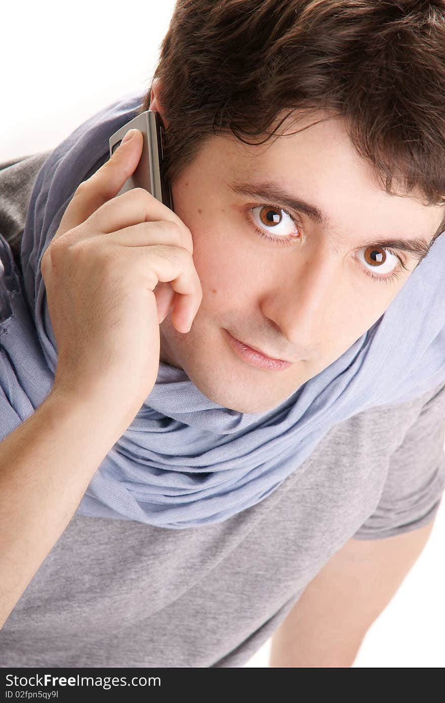 Young attractive smiling man in blue scarf speaking on phone on white bakground. Young attractive smiling man in blue scarf speaking on phone on white bakground