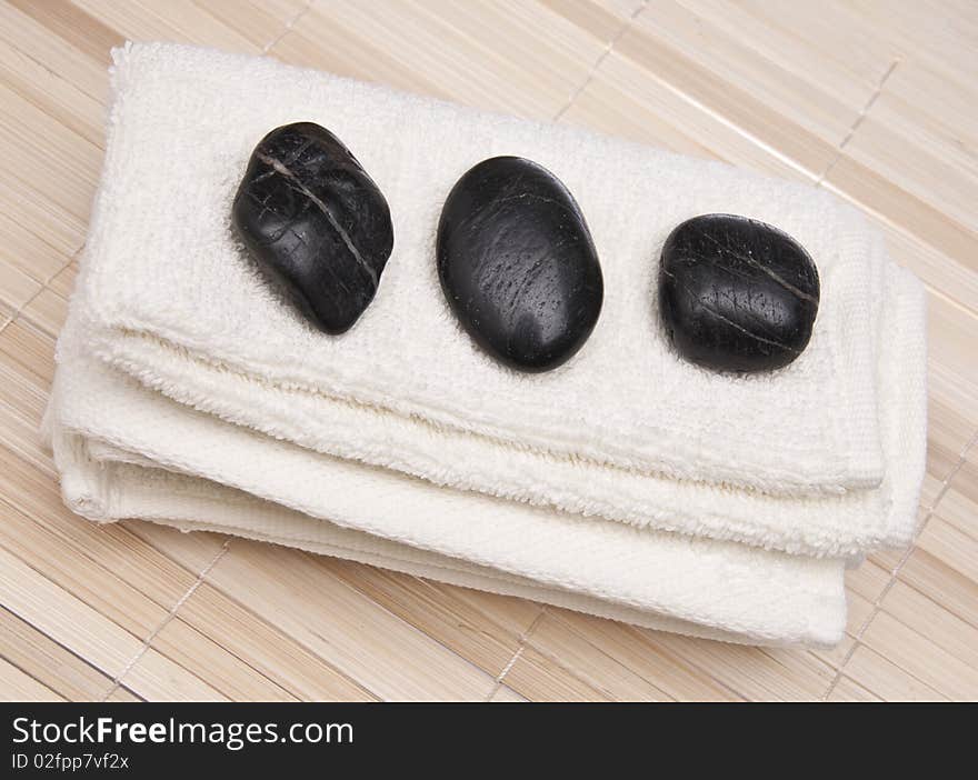 Towel with Massage Stones on a bamboo background.