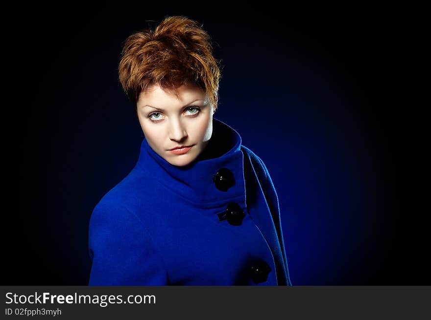 Young lady with short hair dressed in a blue topcoat. Young lady with short hair dressed in a blue topcoat