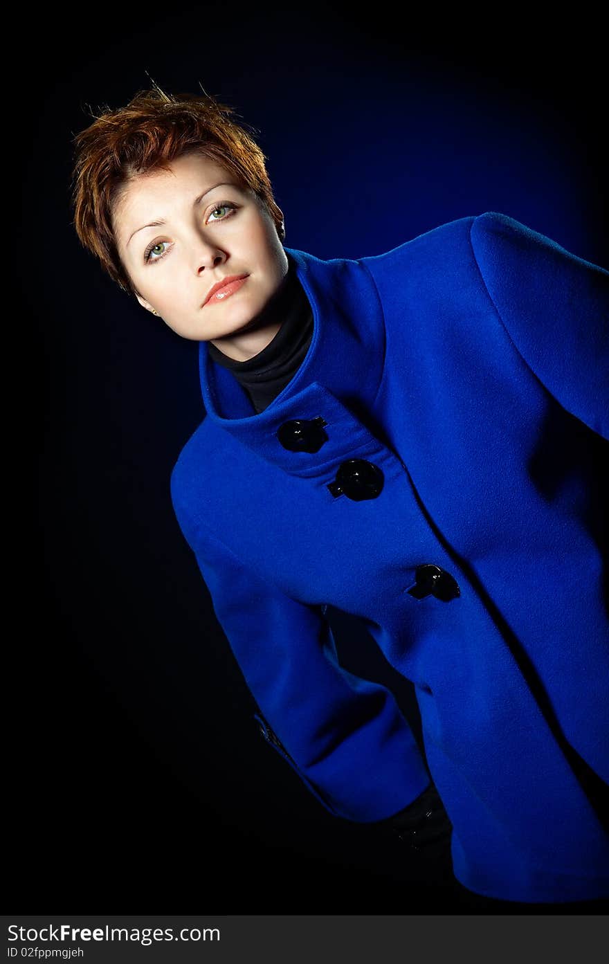 Young lady with short hair dressed in a blue topcoat. Young lady with short hair dressed in a blue topcoat