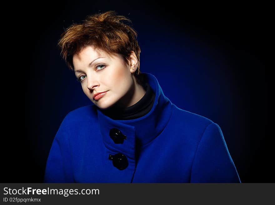 Young lady with short hair dressed in a blue topcoat. Young lady with short hair dressed in a blue topcoat