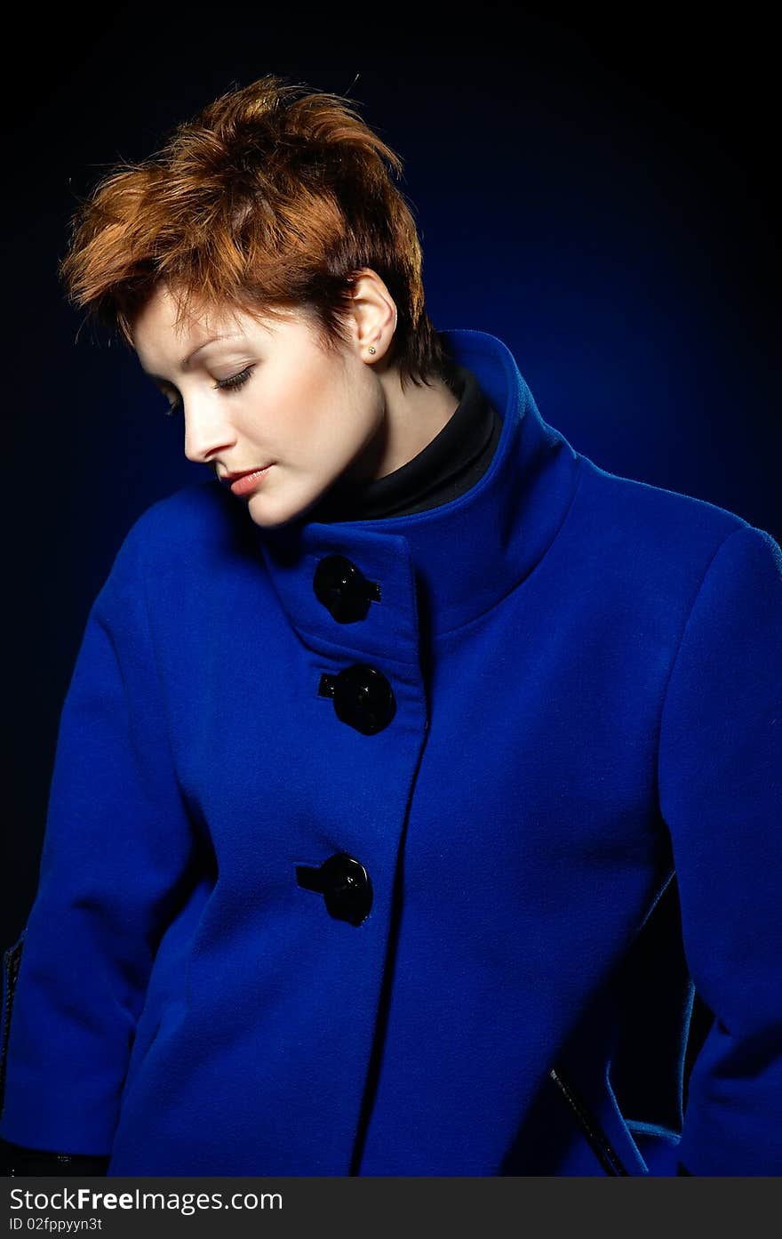 Young lady with short hair dressed in a blue topcoat. Young lady with short hair dressed in a blue topcoat