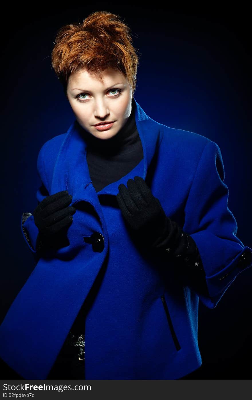 Young lady with short hair dressed in a blue topcoat. Young lady with short hair dressed in a blue topcoat