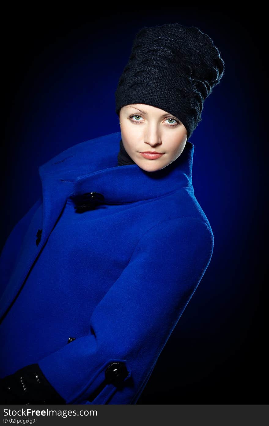 Young lady dressed in a blue topcoat and black hat. Young lady dressed in a blue topcoat and black hat