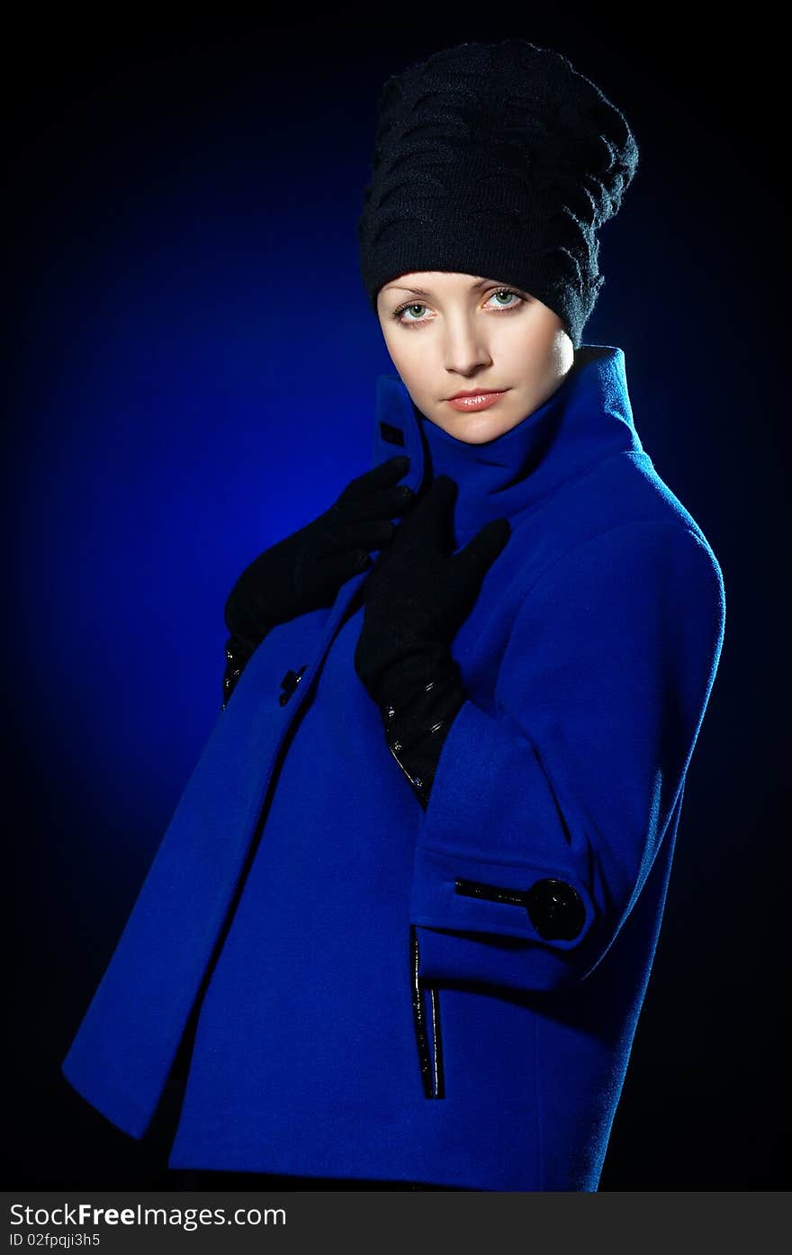 Young lady dressed in a blue topcoat and black hat. Young lady dressed in a blue topcoat and black hat