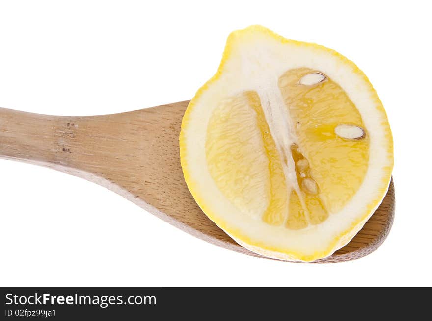 Vibrant lemon in a wooden spoon isolated on white with a clipping path.