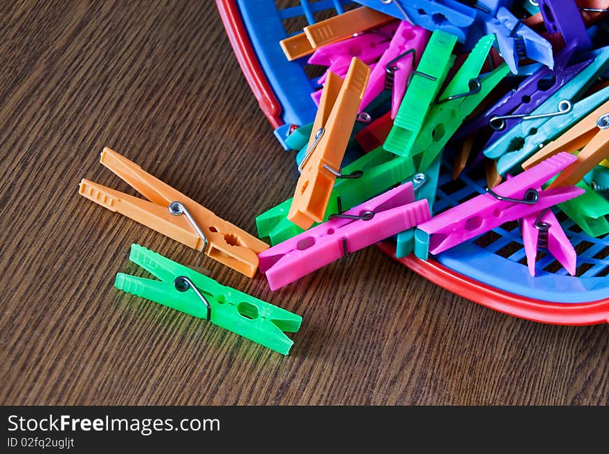 Colored clothespins from basket placed on table