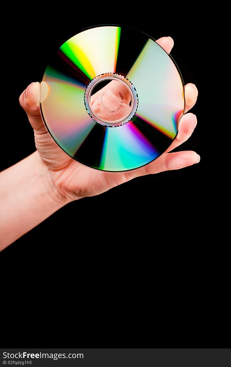 A hand holding a CD on black background