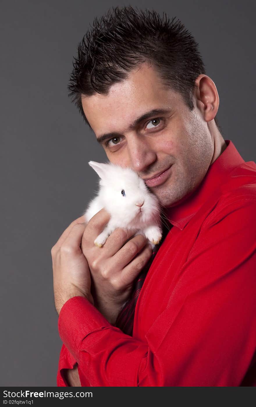 Handsome young man holding baby rabbit