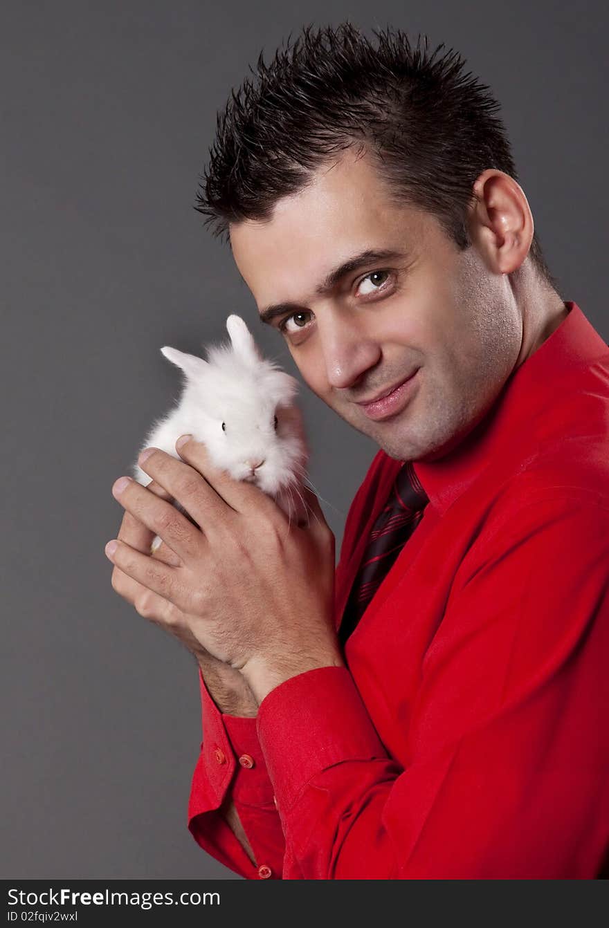 Handsome young man holding baby rabbit. Handsome young man holding baby rabbit