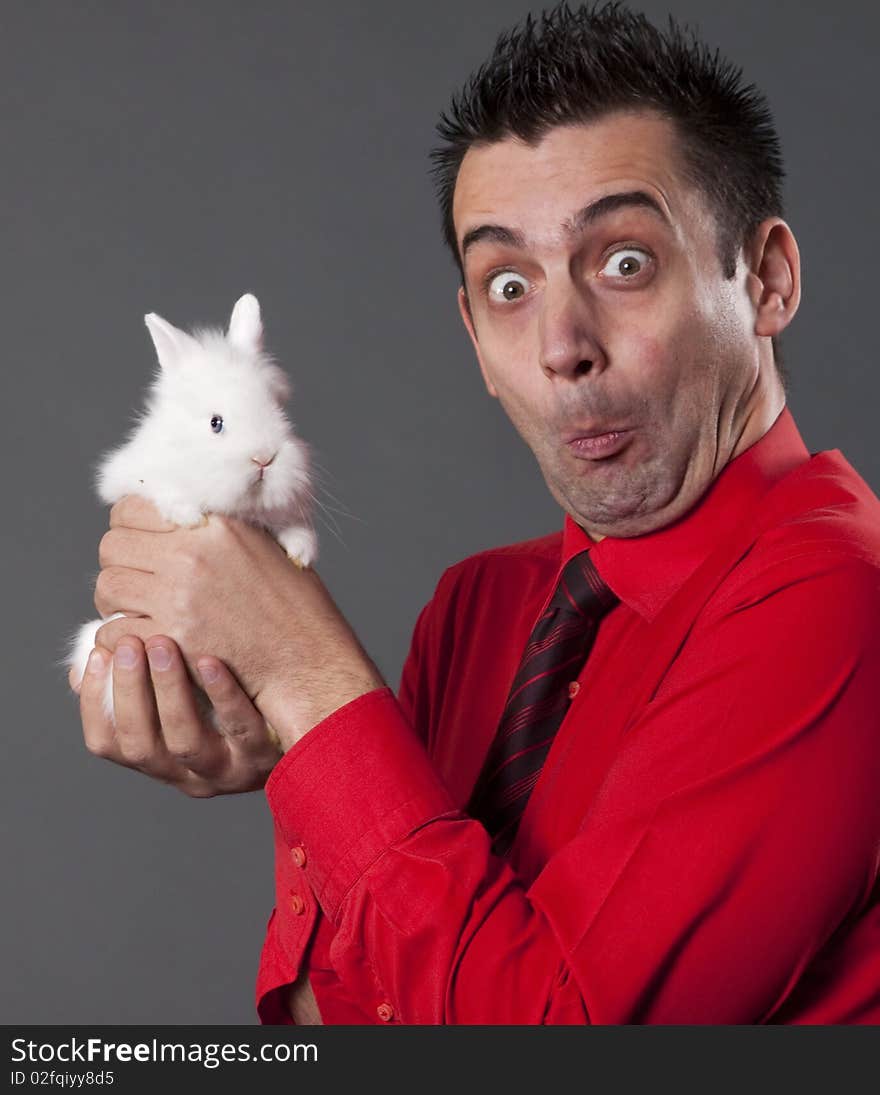 Funny young man holding baby rabbit