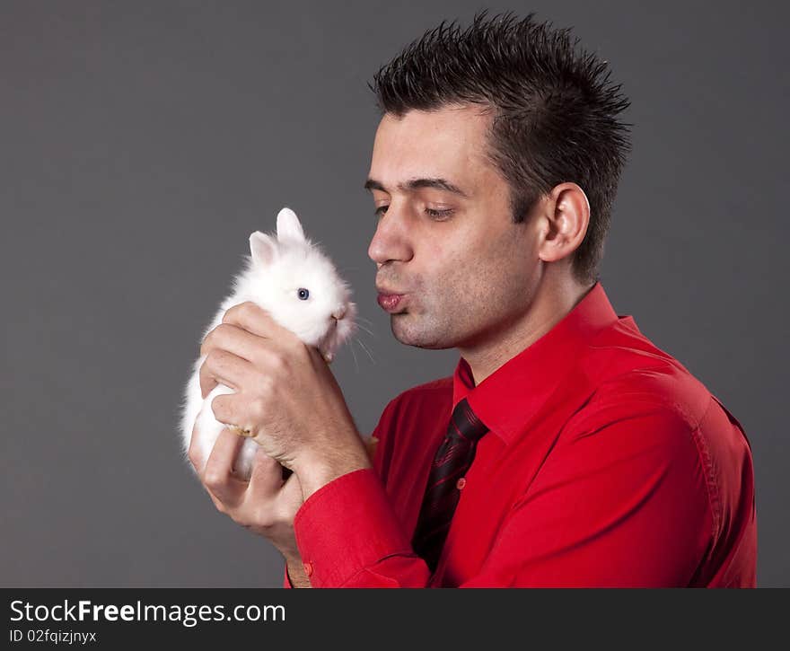 Handsome young man holding baby rabbit. Handsome young man holding baby rabbit