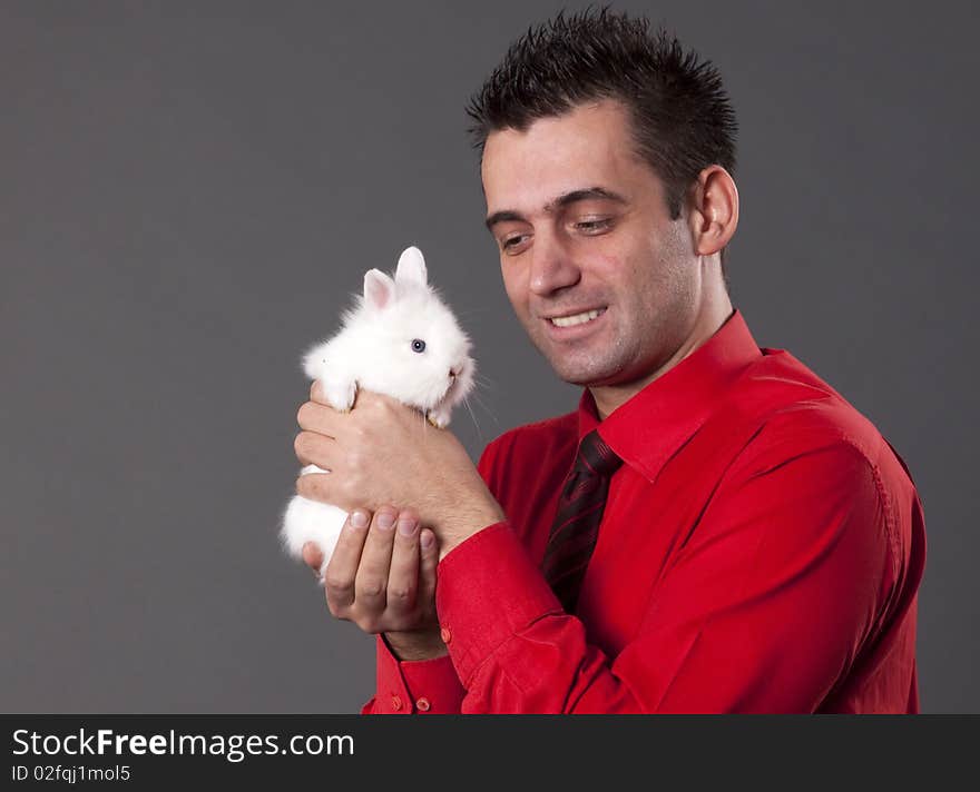 Handsome young man holding baby rabbit. Handsome young man holding baby rabbit