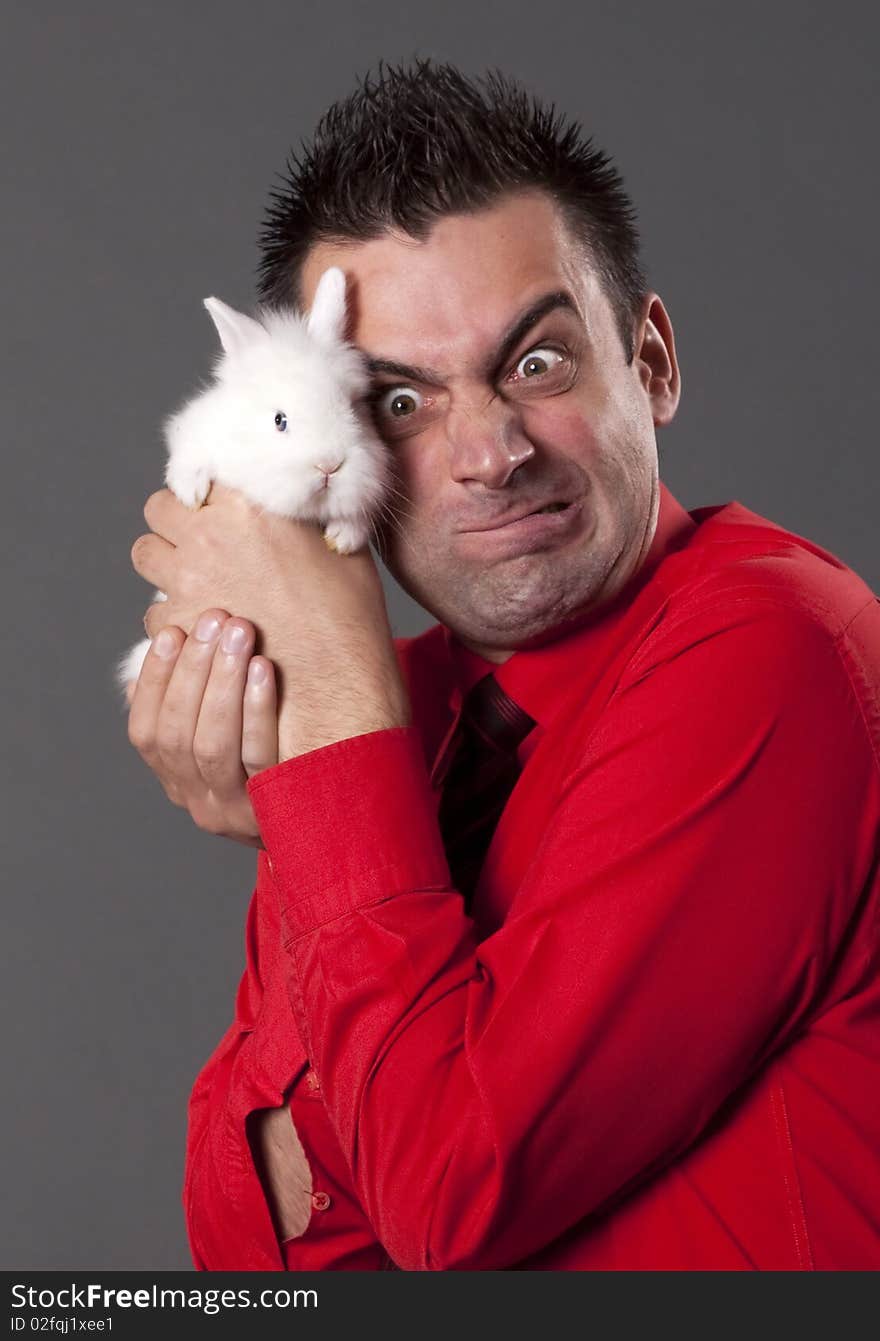 Funny young man holding white rabbit