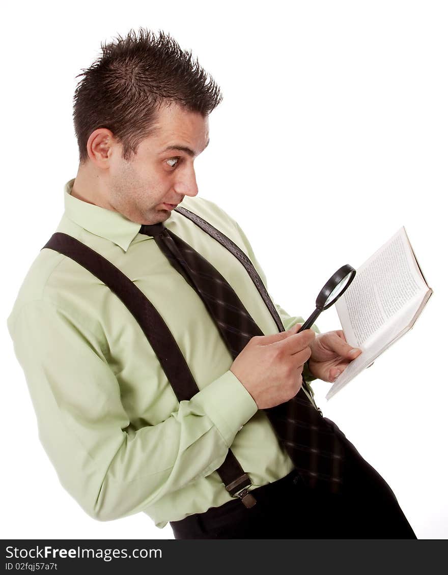 Funny businessman reading a book with magnifying glass