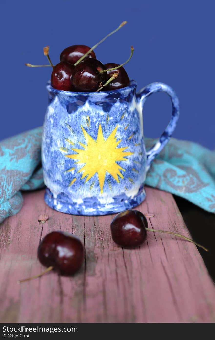 Sweet cherries and old ceramic  mug