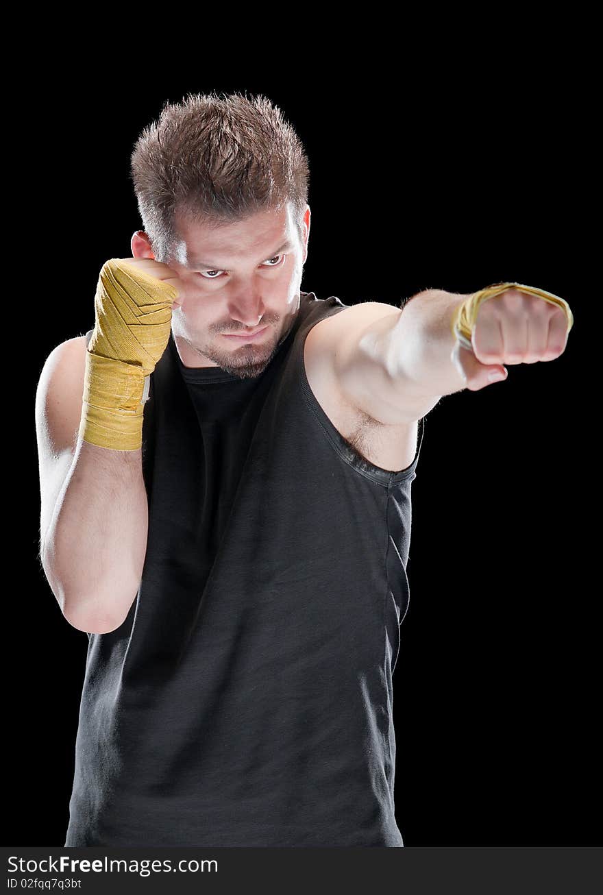 Young man in defensive boxing pose isolated on black. Young man in defensive boxing pose isolated on black