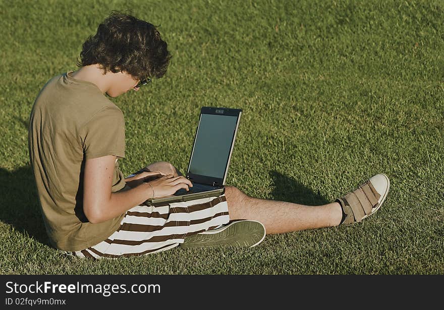 Young woman sitting in green grass