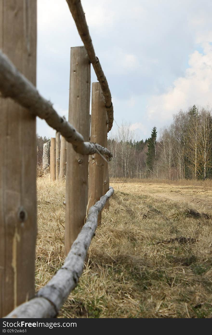 Fence from wooden poles in village