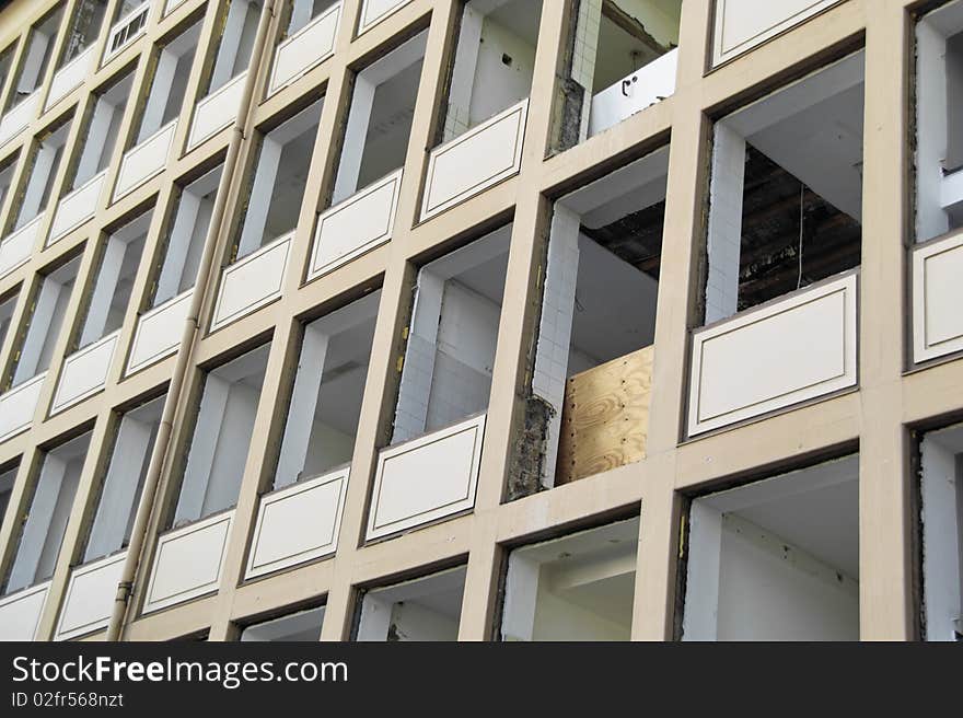 Deconstruction Site of an Older Office Building, prepared to be Torn Down, empty facade and missing windows