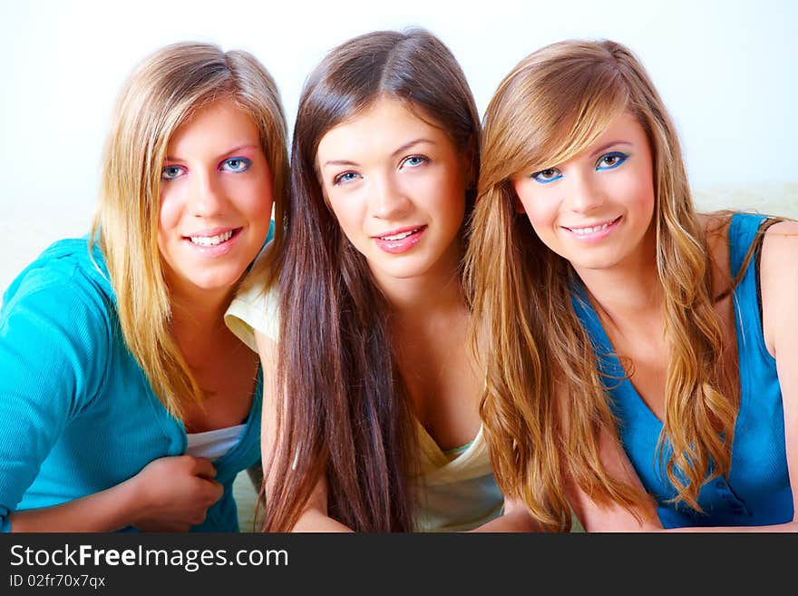 Two beautiful girls sitting on sofa in home with faces close to each other. Two beautiful girls sitting on sofa in home with faces close to each other