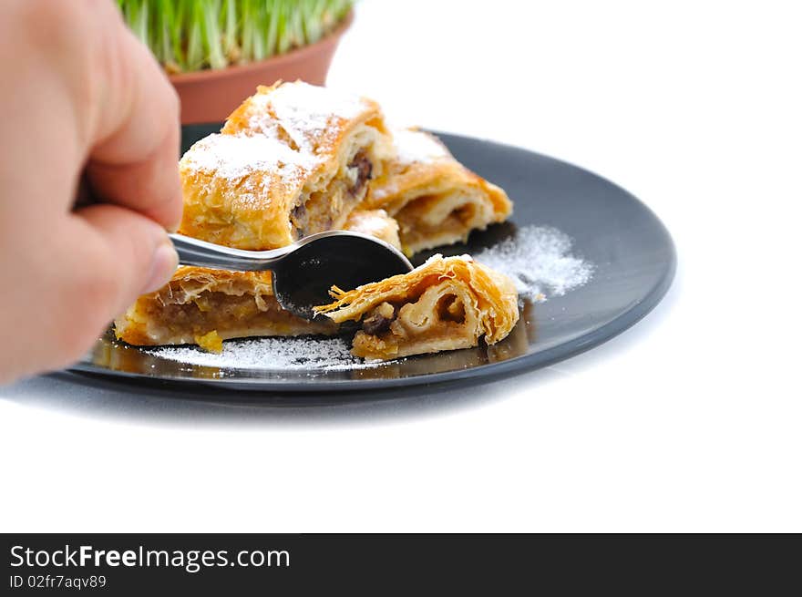 Czech apple pie on black plate and hand which cut pie