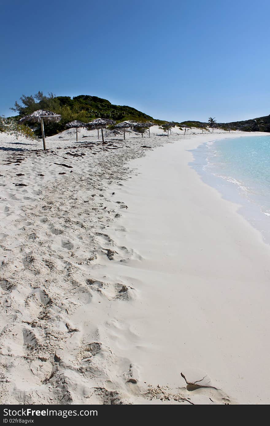 A beach scene with beautiful sand, water, and umbrellas. Island located in the Bahamas near Nassau. A beach scene with beautiful sand, water, and umbrellas. Island located in the Bahamas near Nassau