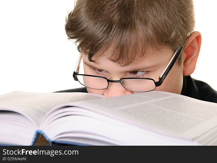 Boy wearing spectacles attentively reads book is isolated on white