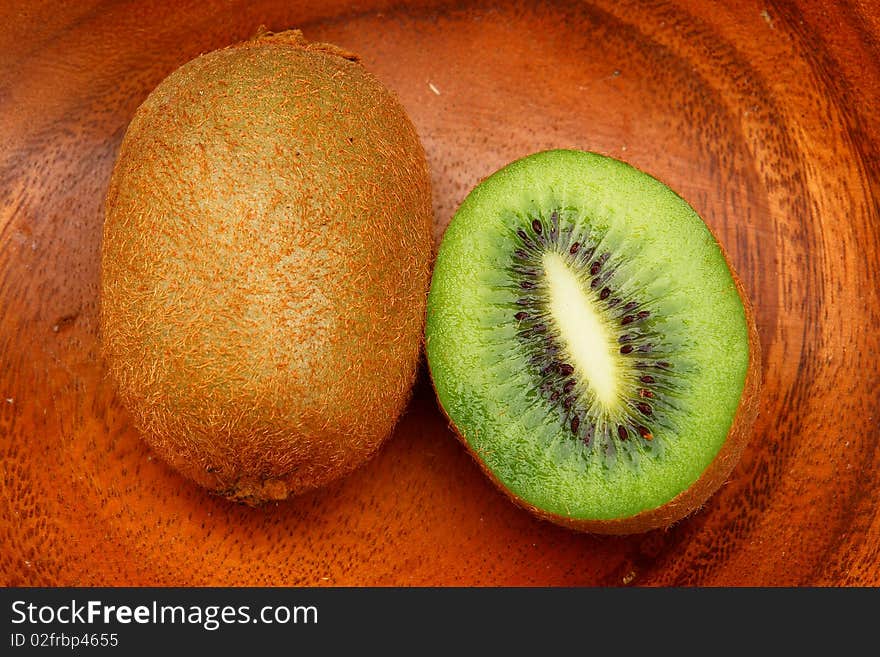 Kiwi fruit on a wooden plate.