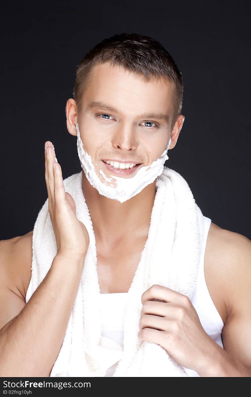 Portrait of young handsome men shaving on a black background. Portrait of young handsome men shaving on a black background