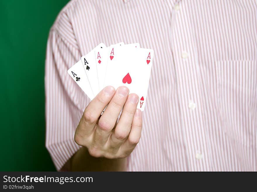 A young man in a red striped shirt, holding four aces. A young man in a red striped shirt, holding four aces