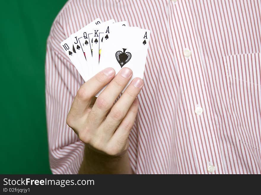 A young man in a red striped shirt, holding Royal flush