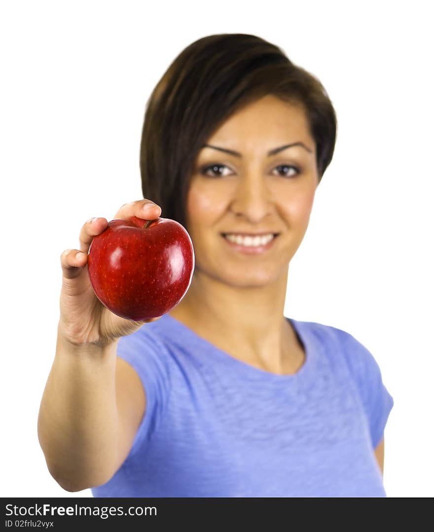 A young ethnic woman holds out a red apple. A young ethnic woman holds out a red apple.