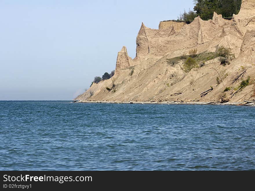 Jagged sandstone cliffs along an ocean coast showing shoreline erosion. Horizontal shot. Jagged sandstone cliffs along an ocean coast showing shoreline erosion. Horizontal shot.