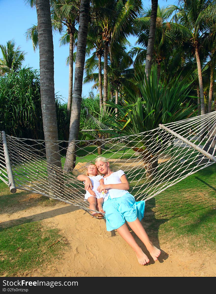 Happy woman and little girl in a hammock