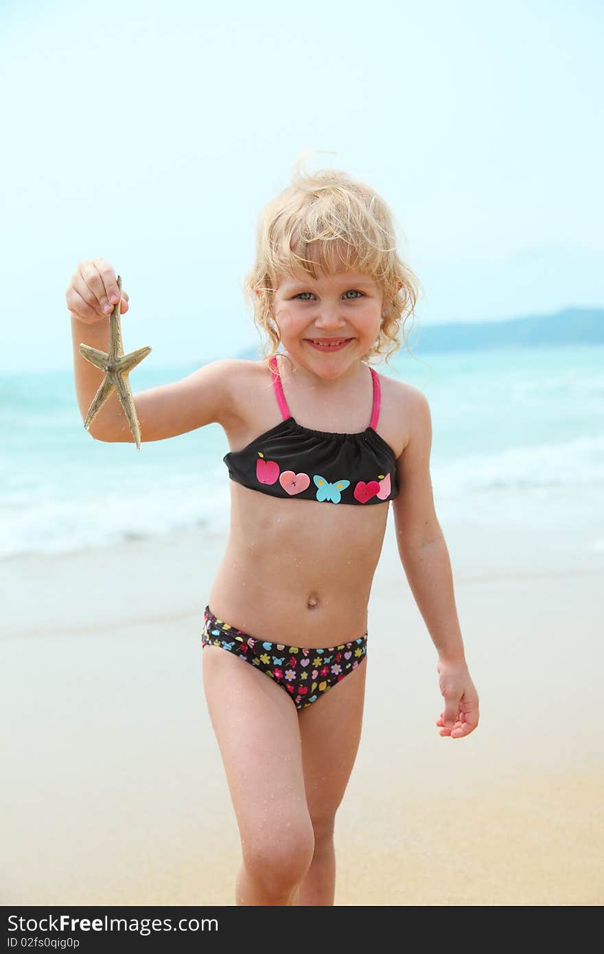 Happy funny girl on the beach with starfish. Happy funny girl on the beach with starfish