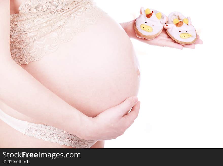 Pregnant woman expecting a birth of the baby, holds bootees