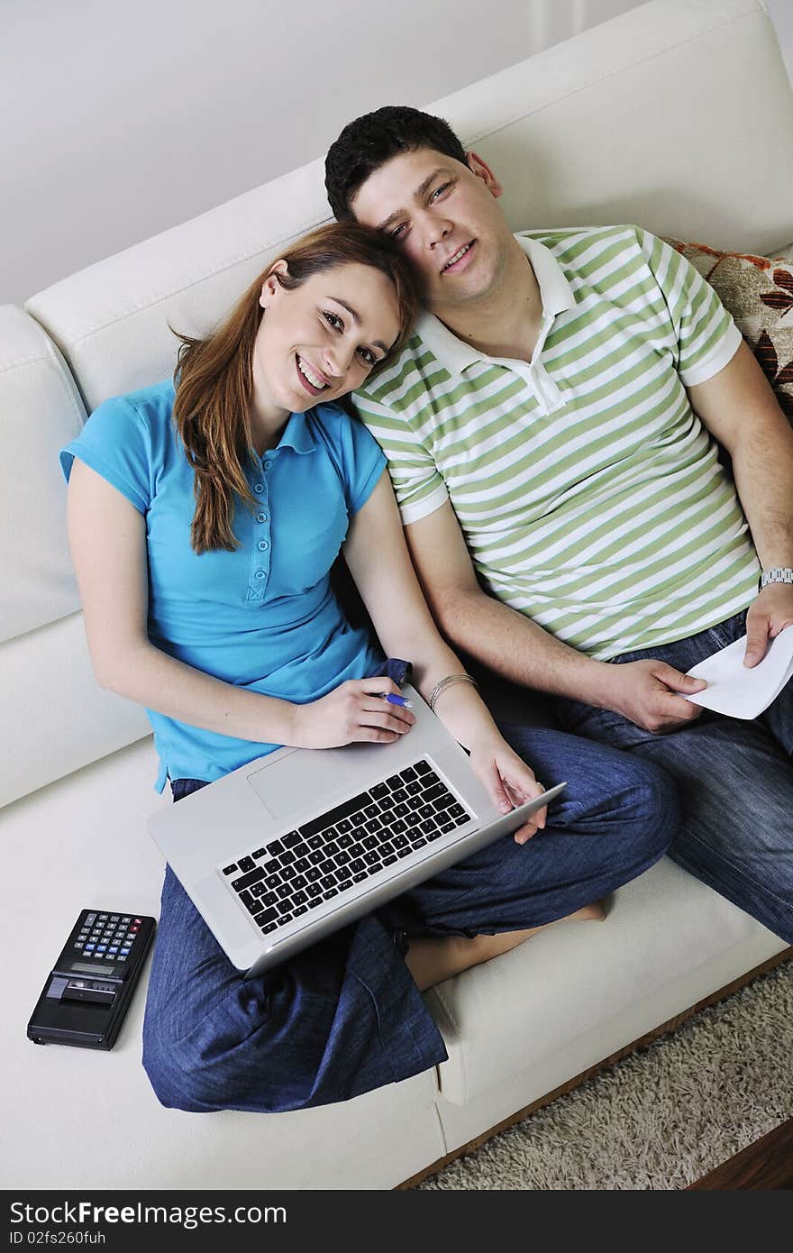 Young couple at home with  modern livingroom indoor working on laptop on house finance and planing. Young couple at home with  modern livingroom indoor working on laptop on house finance and planing