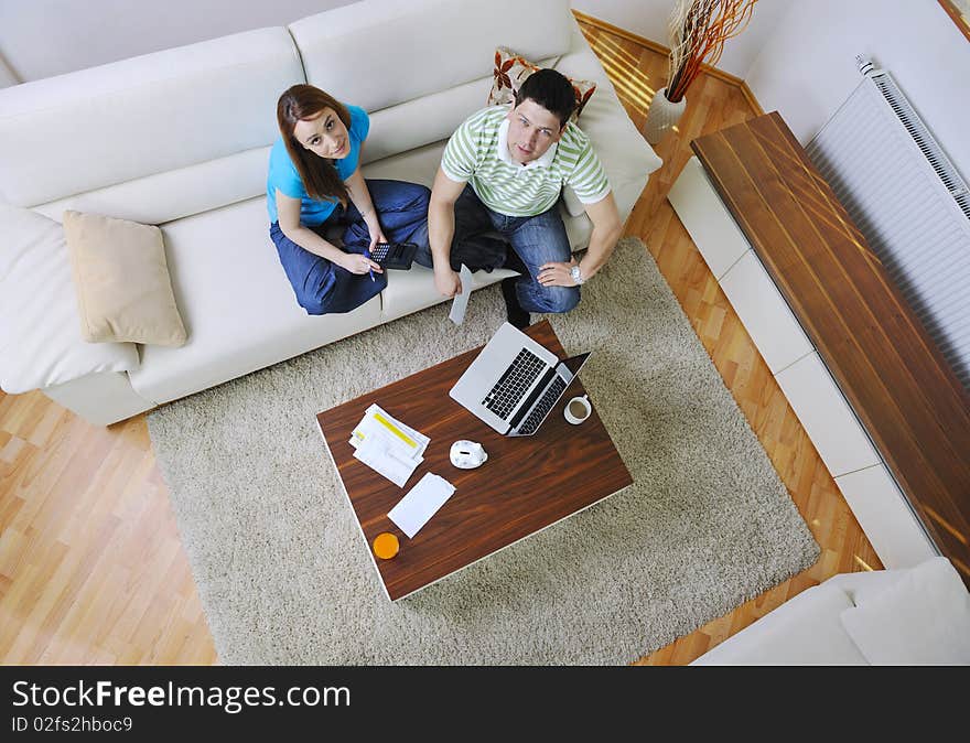 Young couple at home with modern livingroom indoor working on laptop on house finance and planing. Young couple at home with modern livingroom indoor working on laptop on house finance and planing