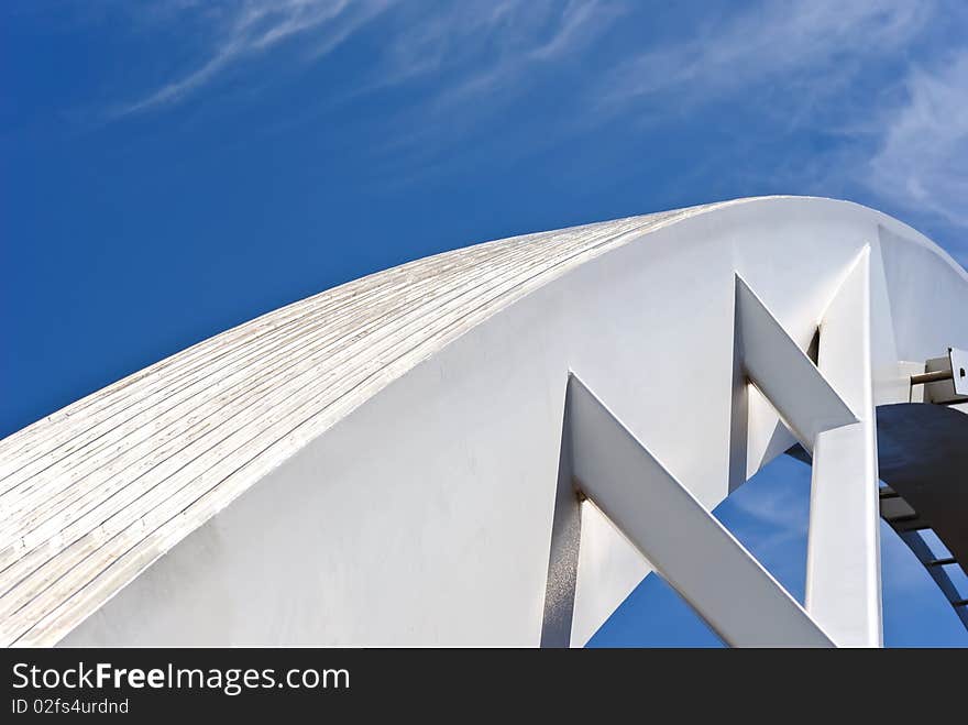 The arc of a modern bridge stands against a clear blue sky in Melbourne, Australia. The arc of a modern bridge stands against a clear blue sky in Melbourne, Australia.