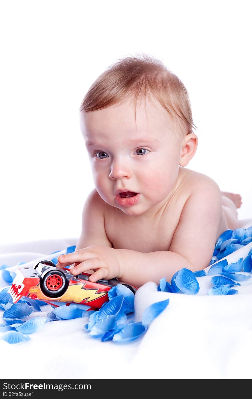 Baby boy playing with red car toy isolated on white