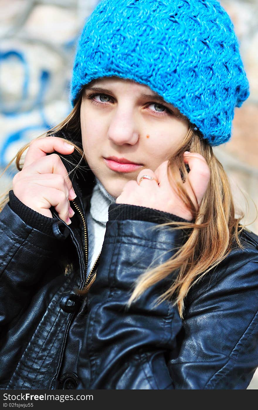 Teen girl wearing blue hat and leather jacket