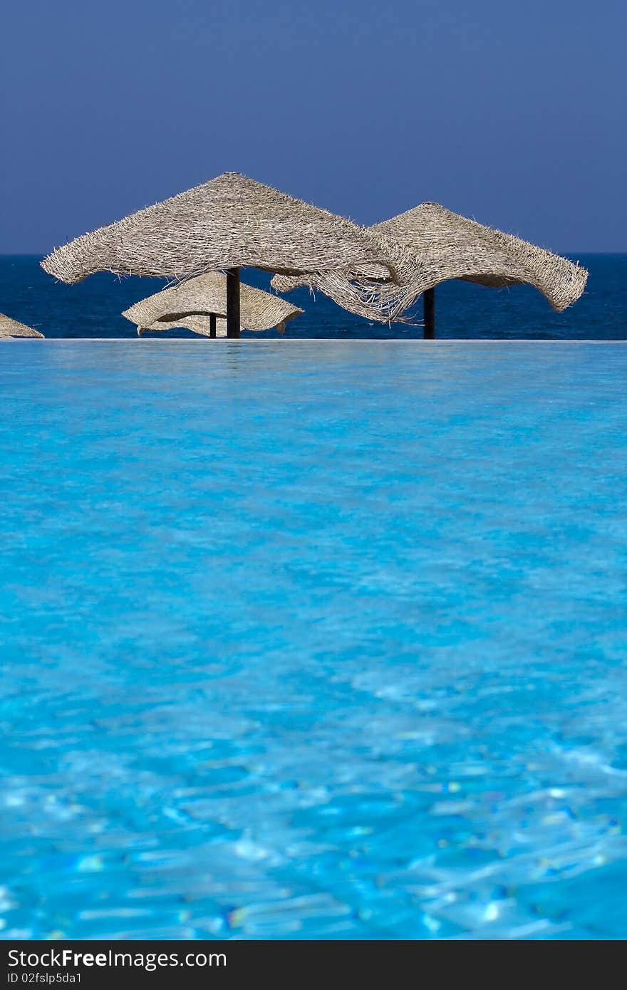 Swimming pool with umbrellas on the beach