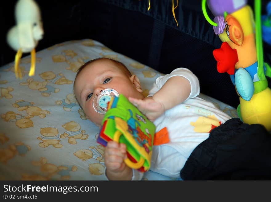 Adorable baby boy playing with his toys