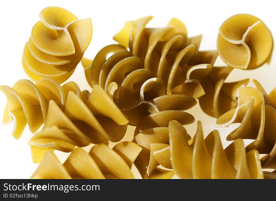 Green pasta spirals against a white background.