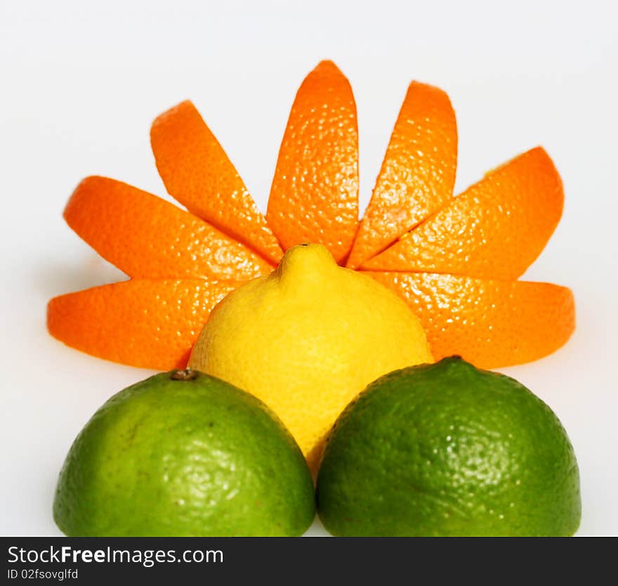 An orange sunset, with a half orange representing the sun, orange segments as the rays and tow limes as the mountains as the sun rises. An orange sunset, with a half orange representing the sun, orange segments as the rays and tow limes as the mountains as the sun rises.