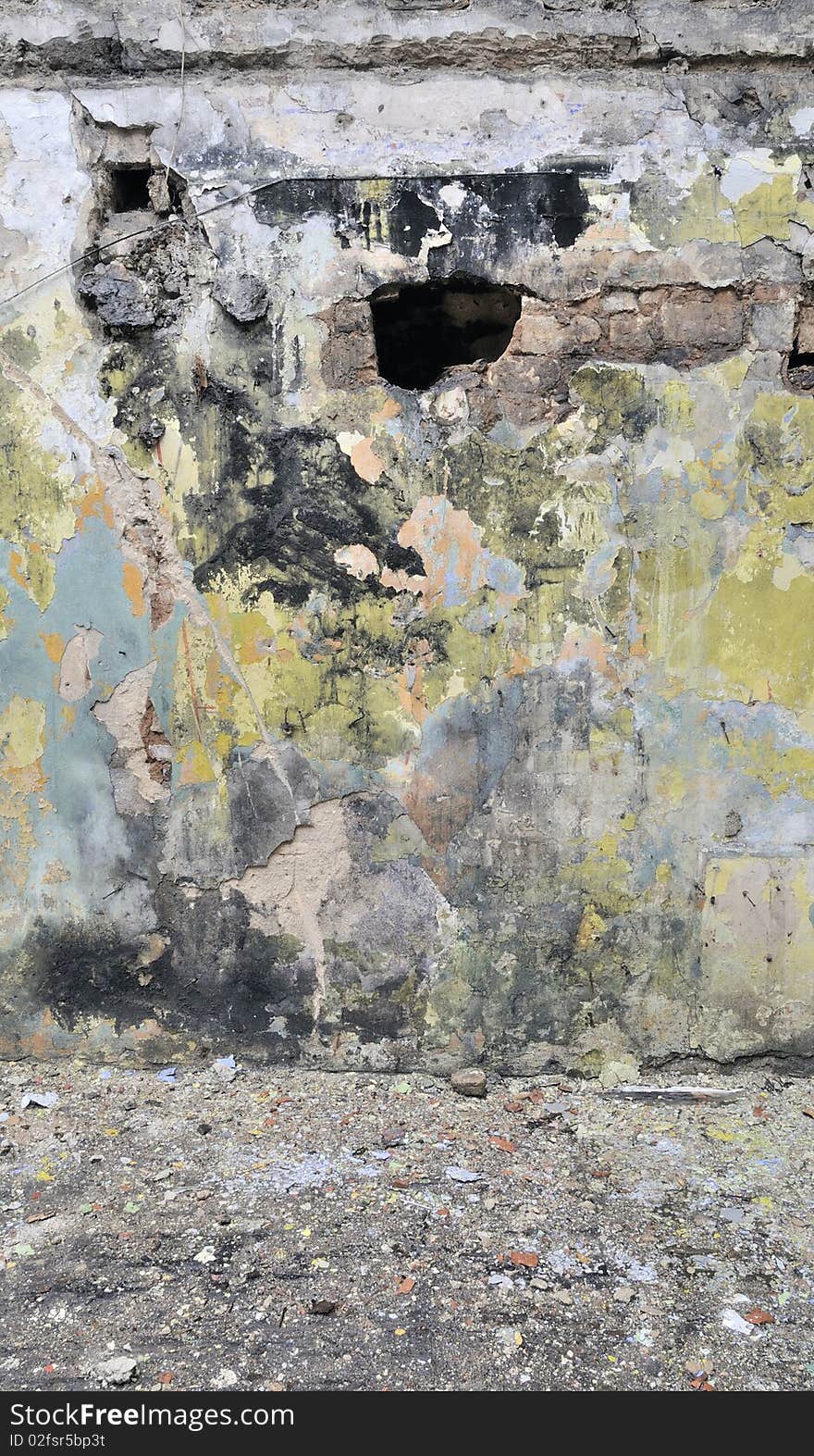 Old wall in broken, fired house. Colour stains of a paint on a wall. Old wall in broken, fired house. Colour stains of a paint on a wall