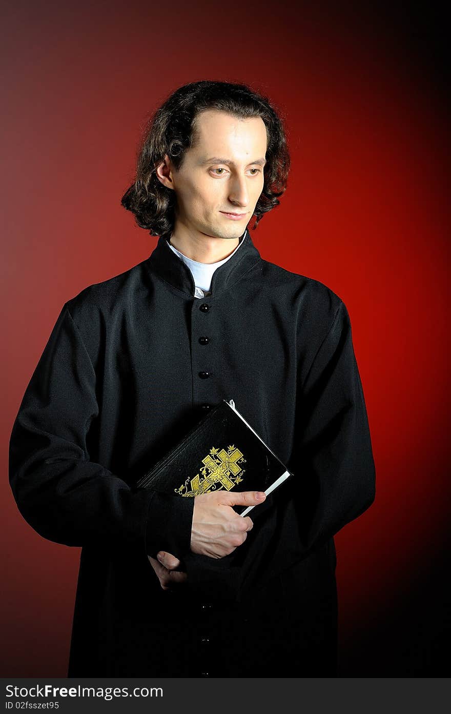 Praying priest with wooden cross