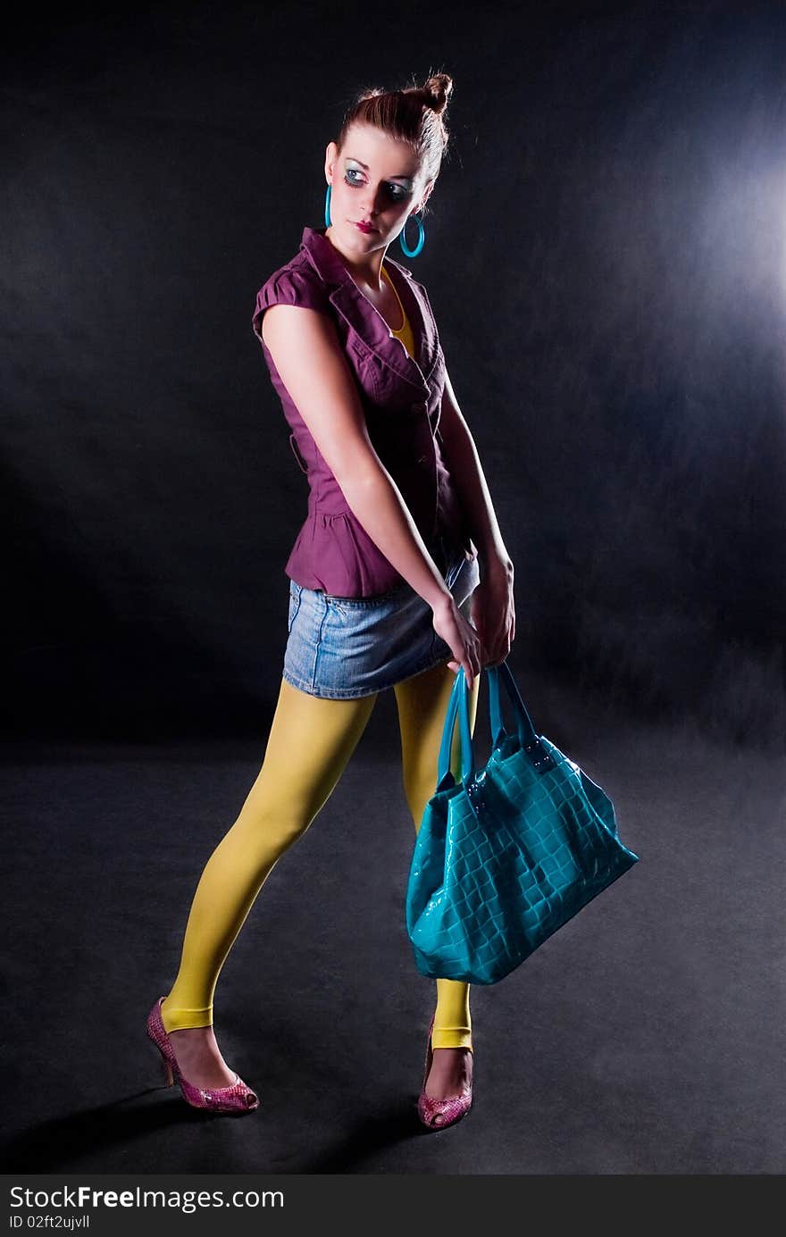 Fashion photo, model with a bag posing on light background. Fashion photo, model with a bag posing on light background